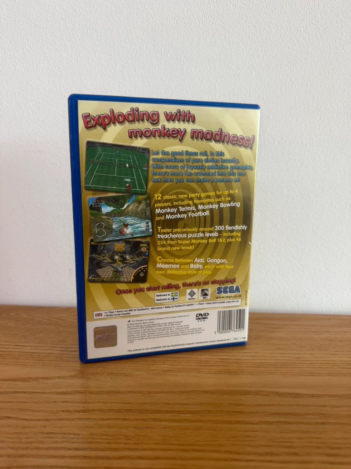 Multiples cream video game accessory with Super Monkey Ball Deluxe cover art and manual.