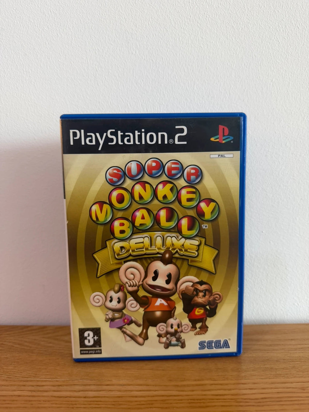 Multiples cream video game accessory with Super Monkey Ball Deluxe cover art and manual.