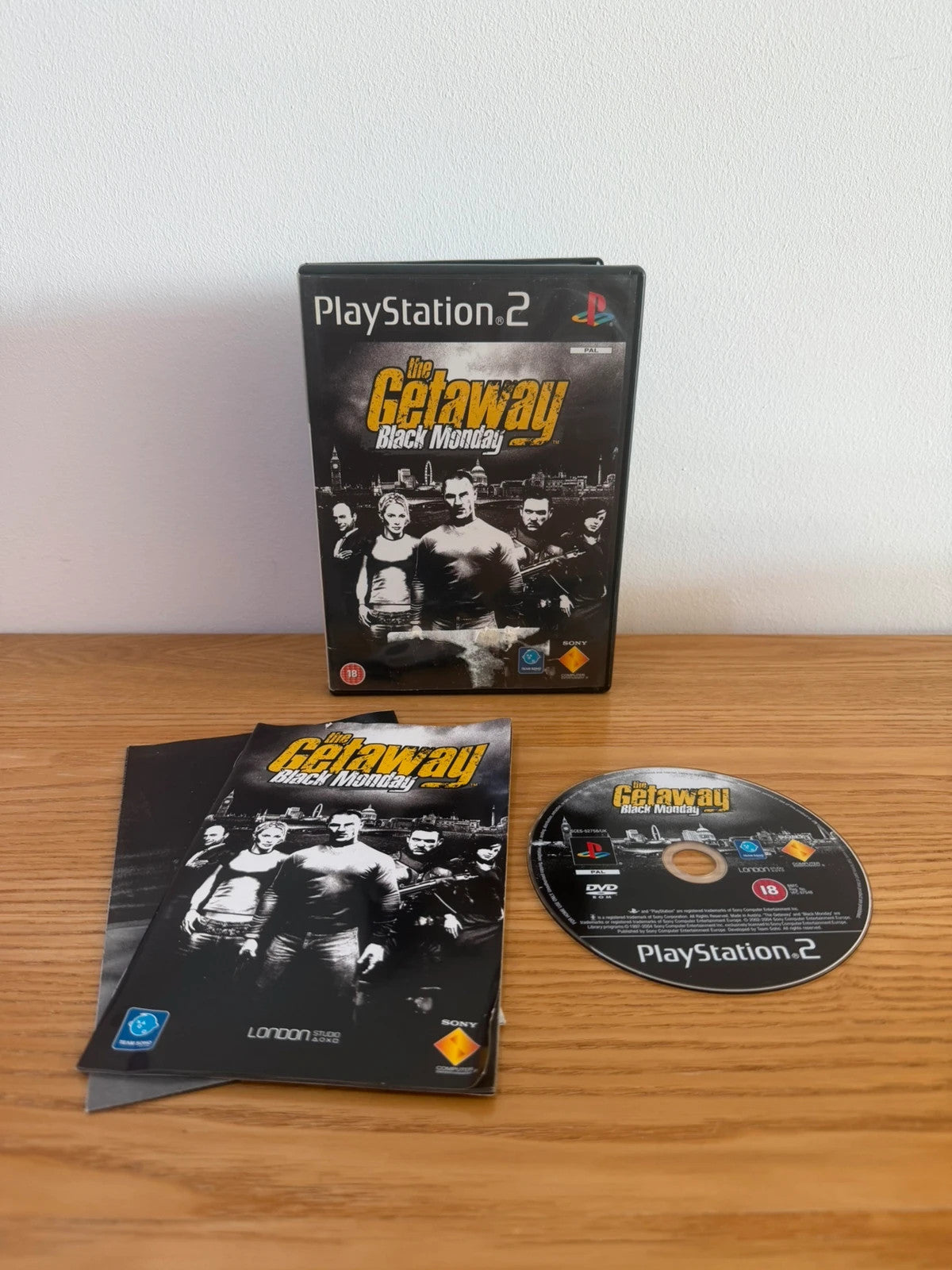 Multiples video game accessory black case with manual, map, and disc for PS2.