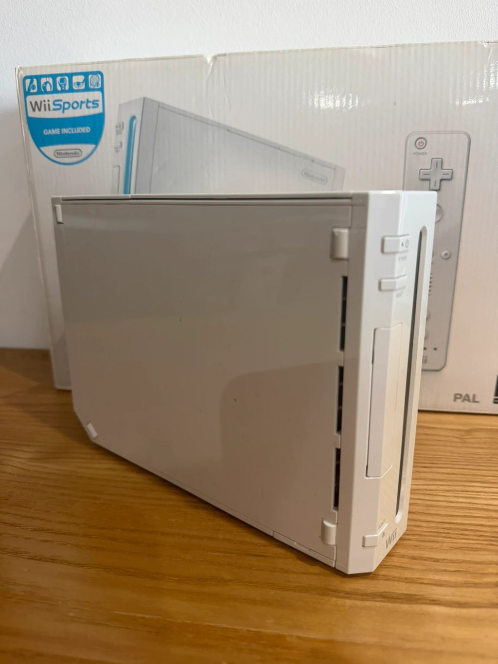 Nintendo white Wii console bundle with original box, remote, and accessories.