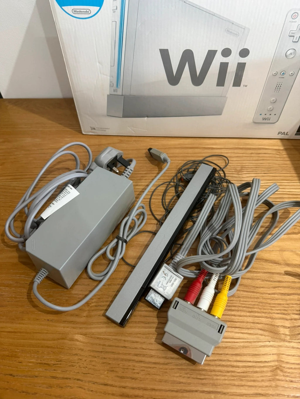 Nintendo white Wii console bundle with original box, remote, and accessories.