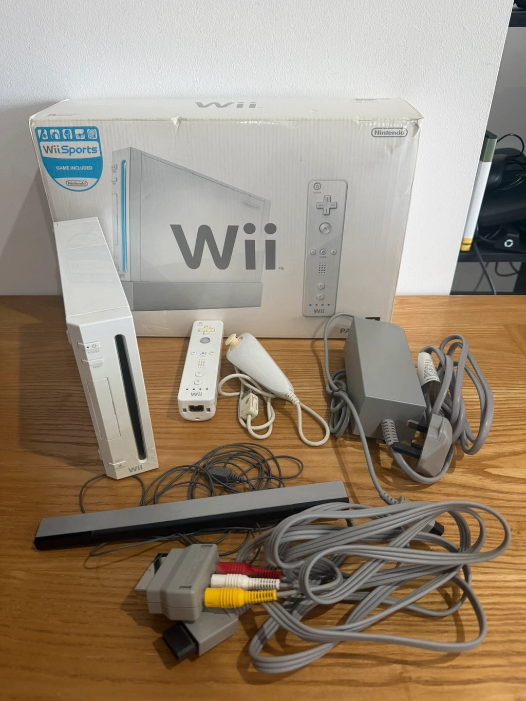 Nintendo white Wii console bundle with original box, remote, and accessories.