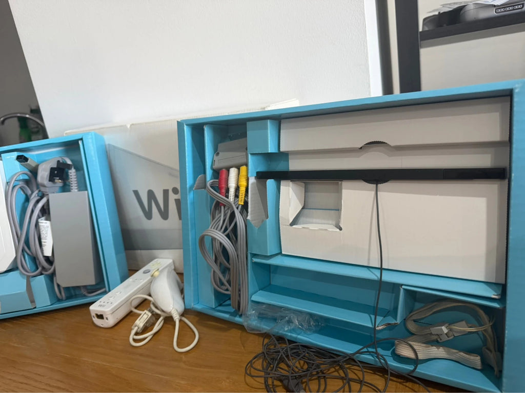 Nintendo white Wii console bundle with original box, remote, and accessories.