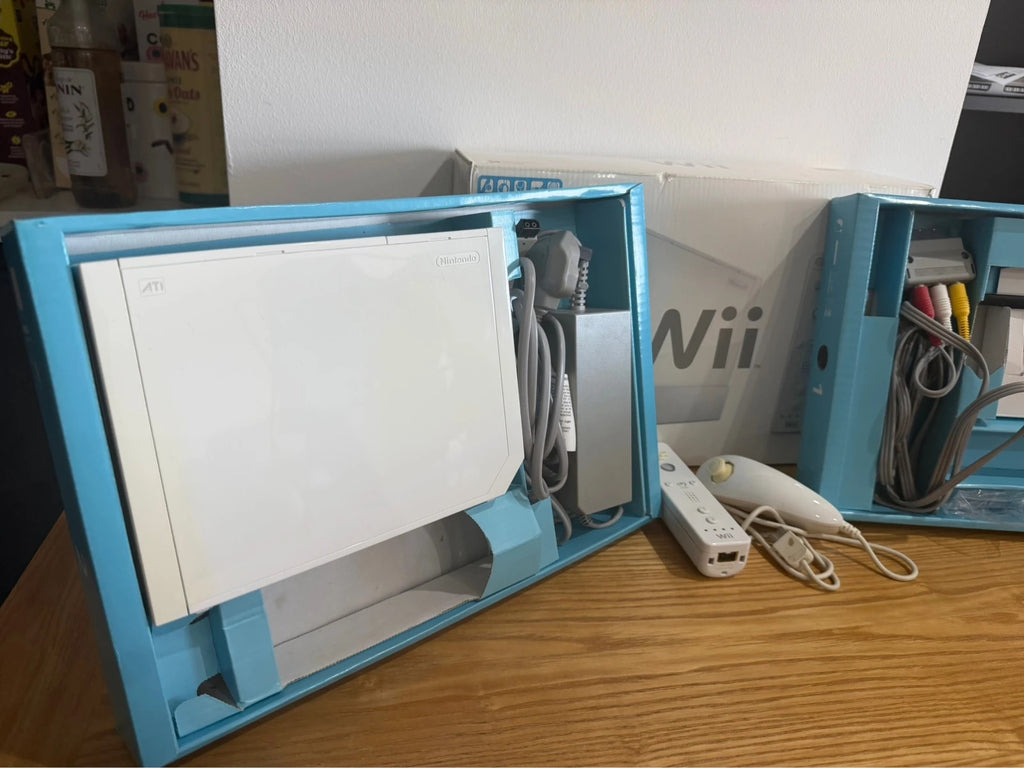 Nintendo white Wii console bundle with original box, remote, and accessories.