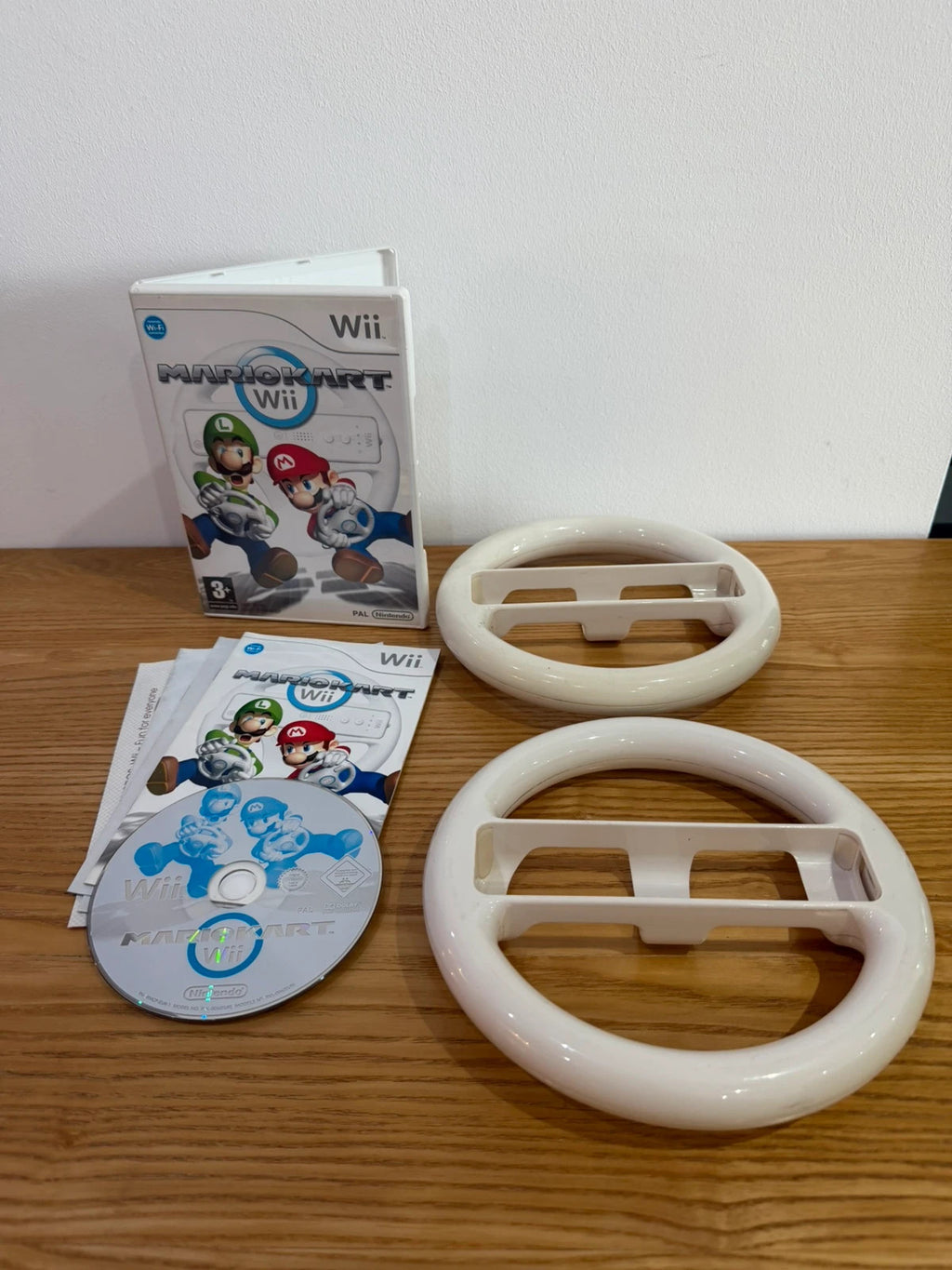 Nintendo Wii Mario Kart game bundle with manual and two steering wheels, very good condition.