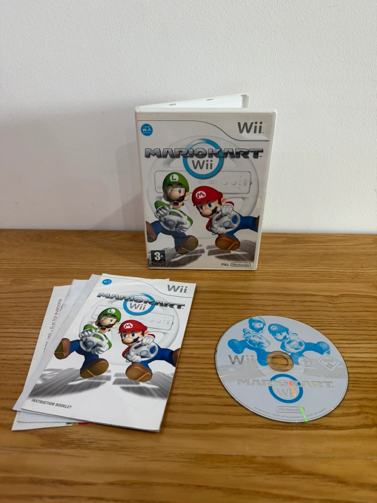 Nintendo Wii Mario Kart game bundle with manual and two steering wheels, very good condition.
