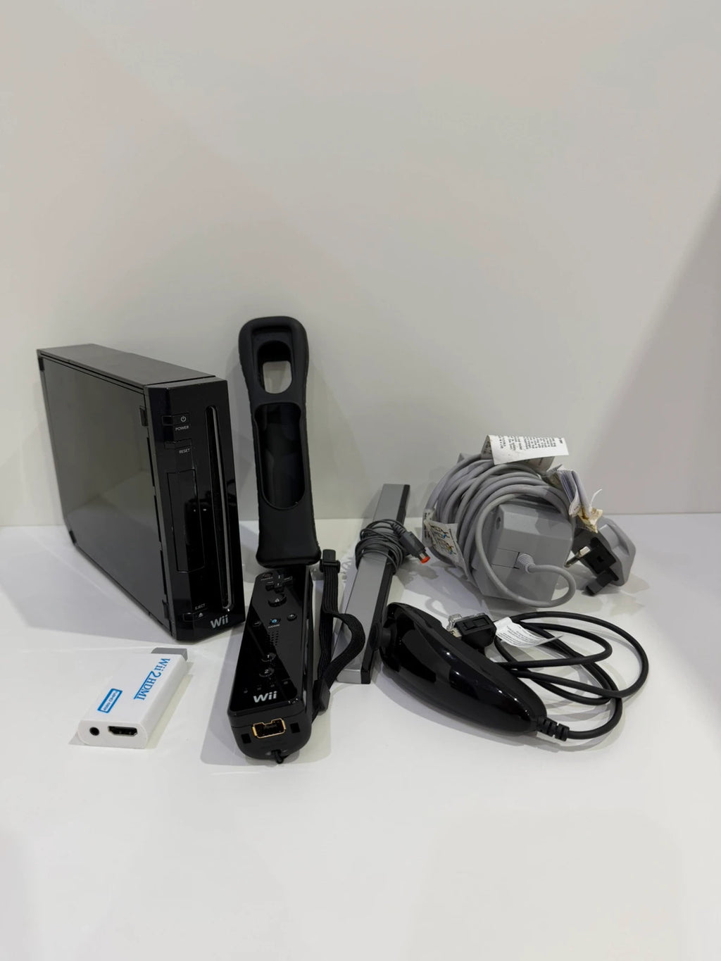 Nintendo black Wii console bundle with official accessories and Wii2HDMI adapter.