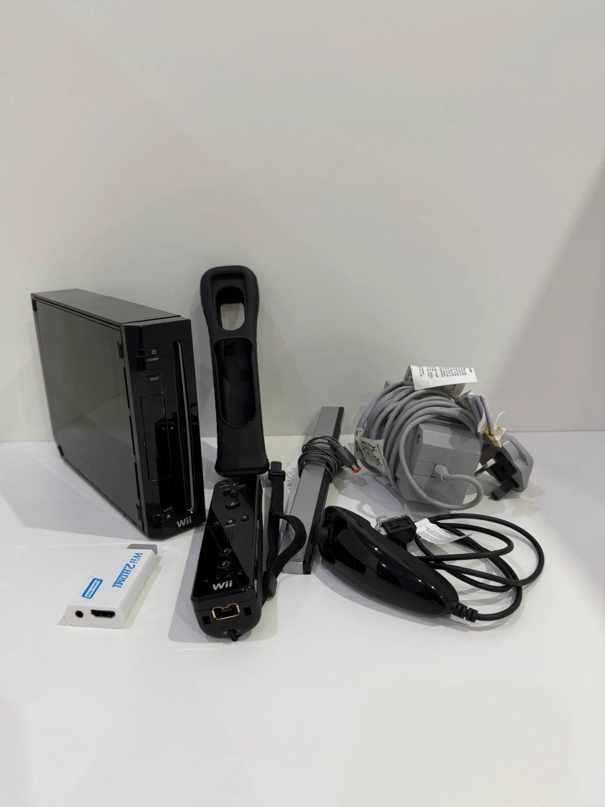 Nintendo black Wii console bundle with official accessories and Wii2HDMI adapter.