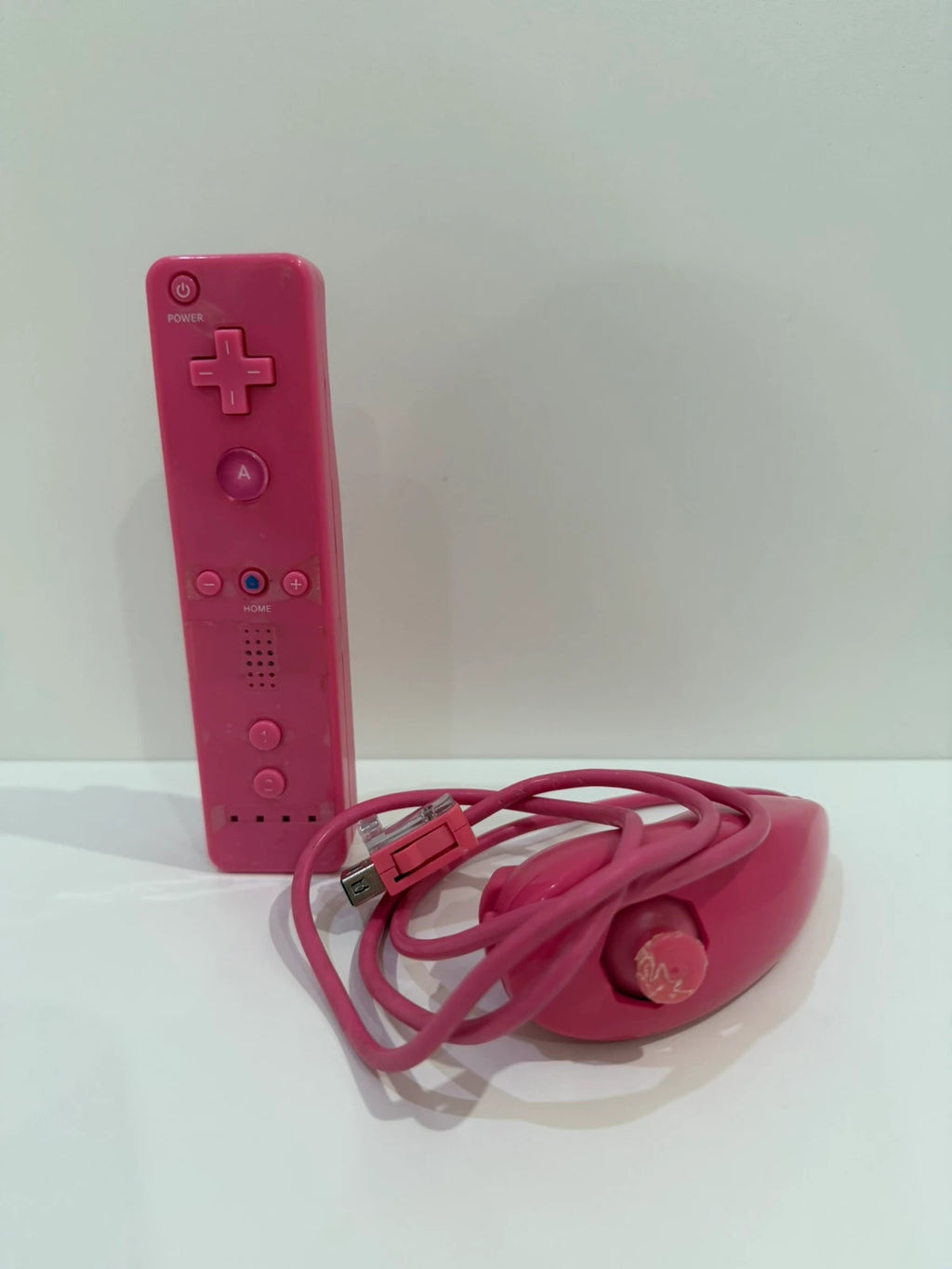 Value pink Wii compatible remote and nunchuk set with ergonomic design and buttons.
