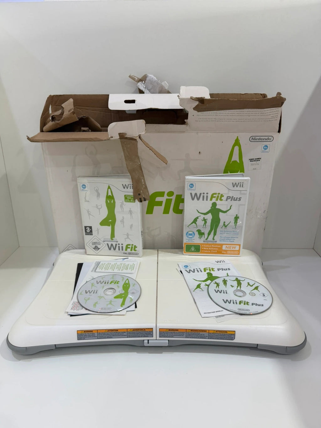 Nintendo Wii Fit Balance Board white with original box, game discs, and booklets.