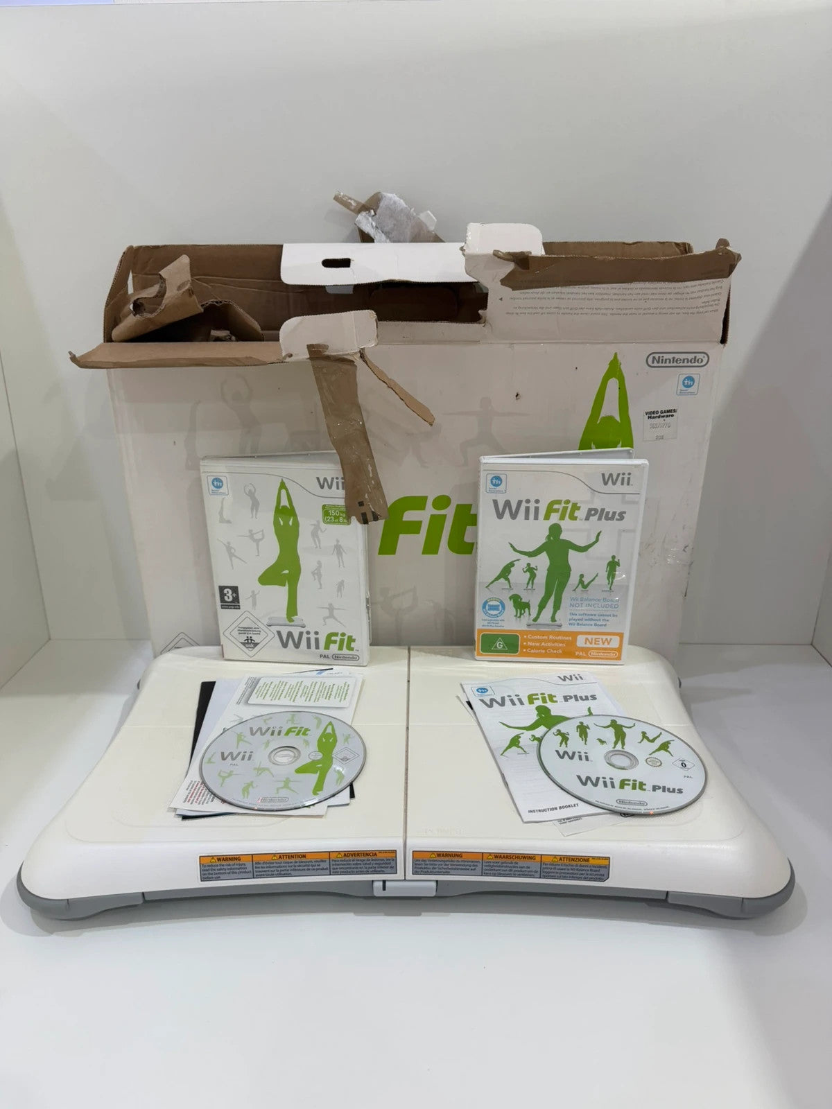 Nintendo Wii Fit Balance Board white with original box, game discs, and booklets.