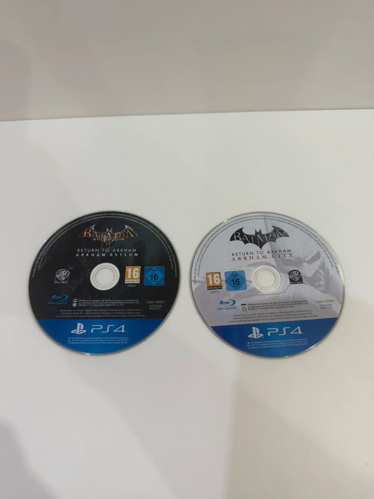 Batman Arkham Collection PS4 game case with cover art and two discs included.