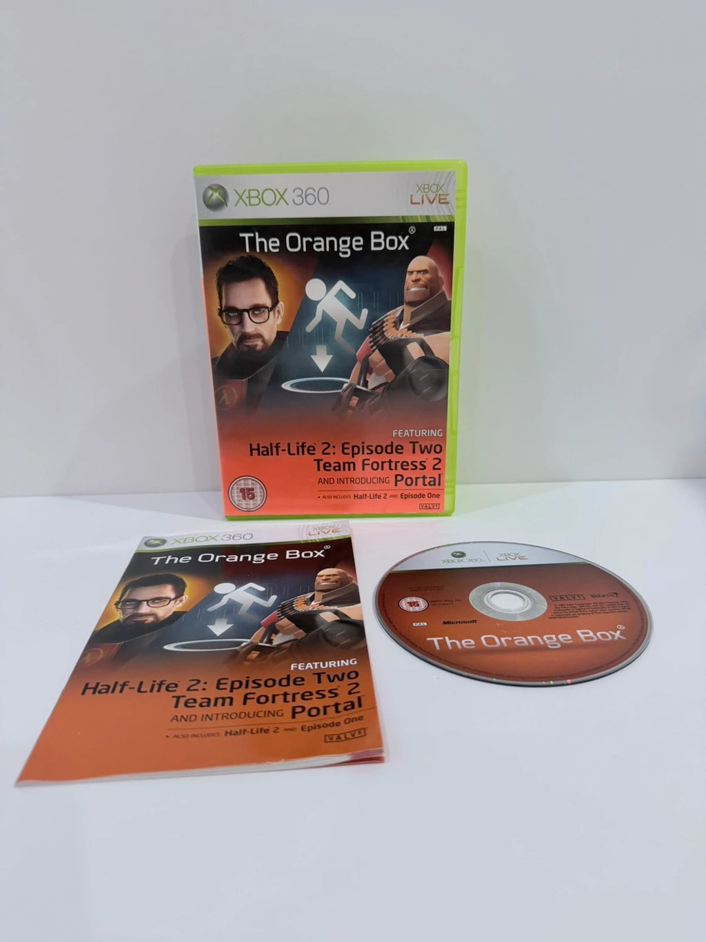 The Orange Box Xbox 360 game set, vibrant orange case with manual and disc.