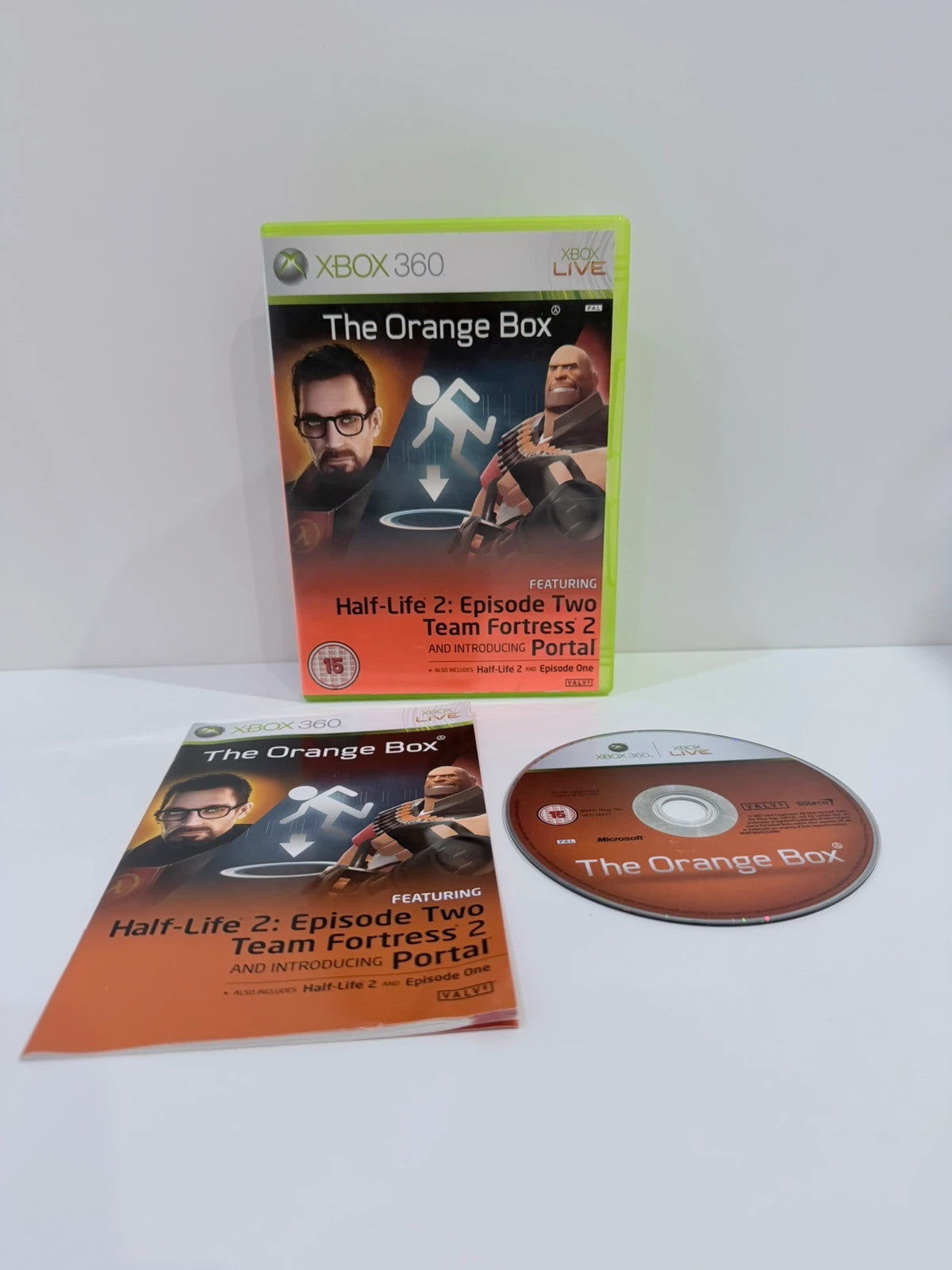 The Orange Box Xbox 360 game set, vibrant orange case with manual and disc.
