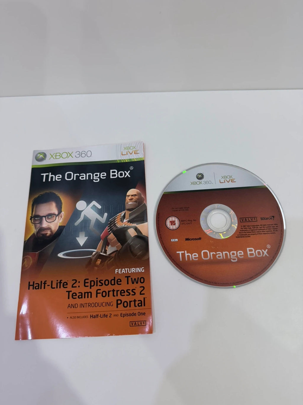 The Orange Box Xbox 360 game set, vibrant orange case with manual and disc.