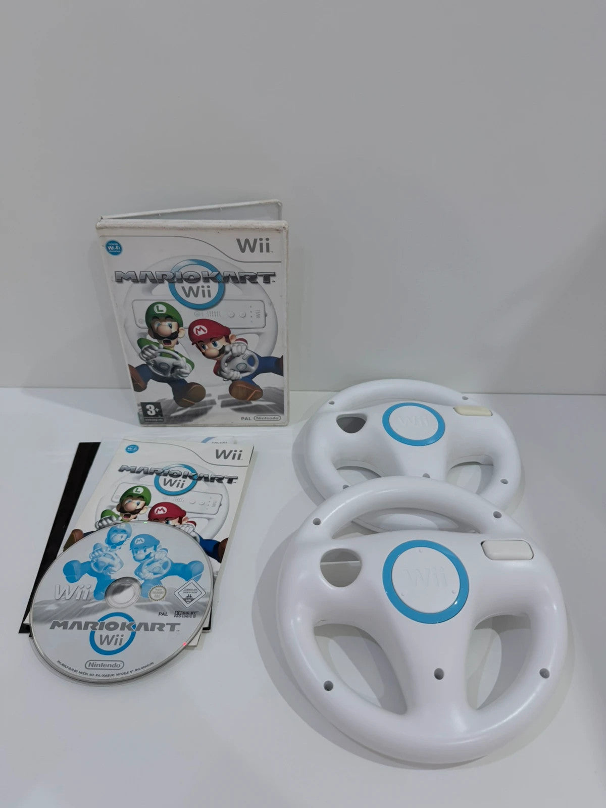 Nintendo Mario Kart Wii video game with case, manual, and two official steering wheels.