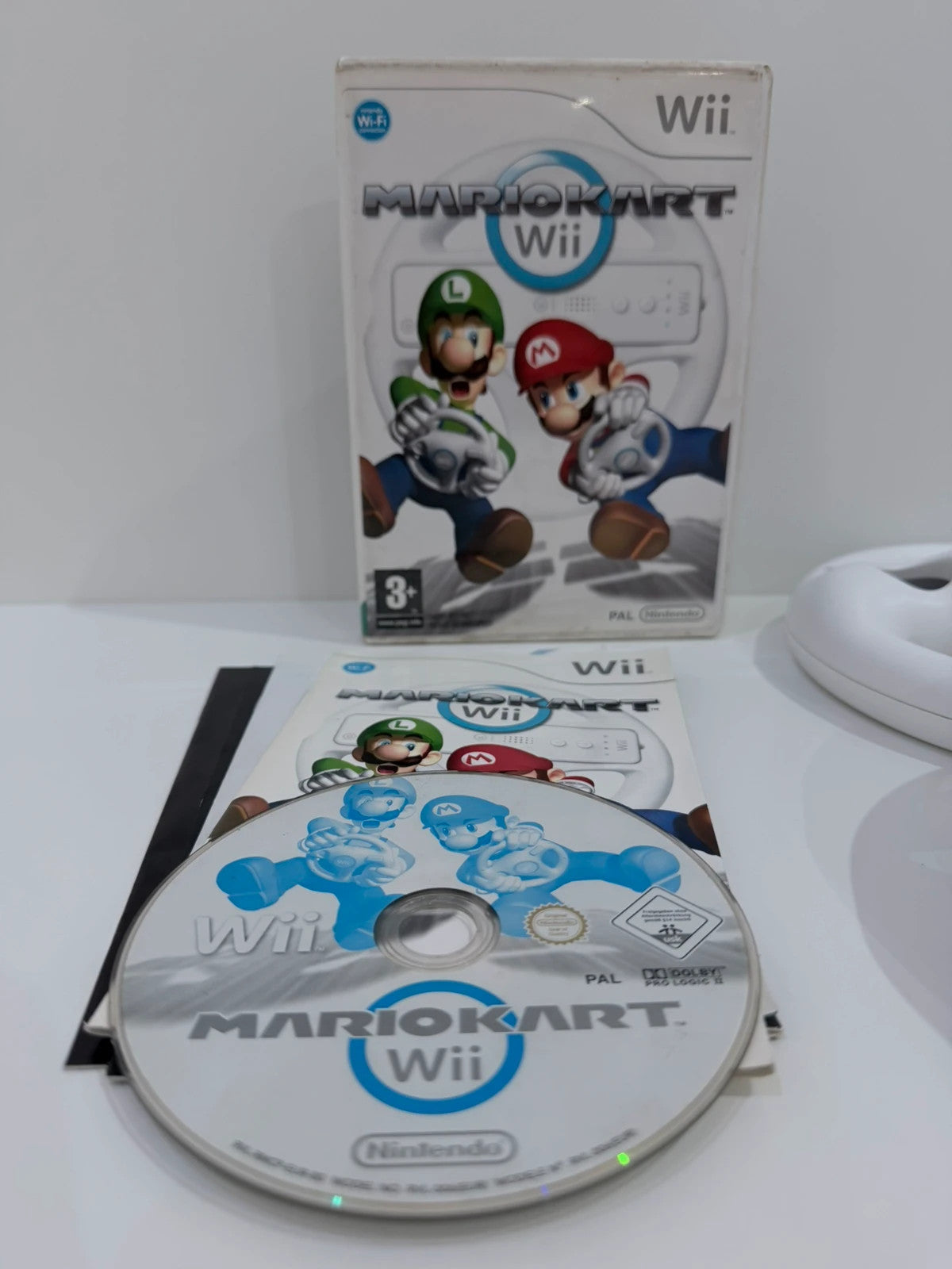 Nintendo Mario Kart Wii video game with case, manual, and two official steering wheels.