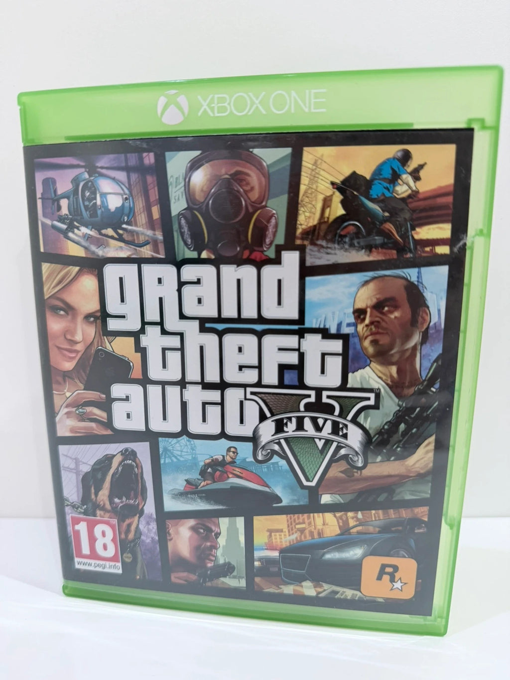 Grand Theft Auto V Xbox One game case with disc, manual, and map included.