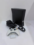 Xbox black video game console with white official controller and power supply cables.