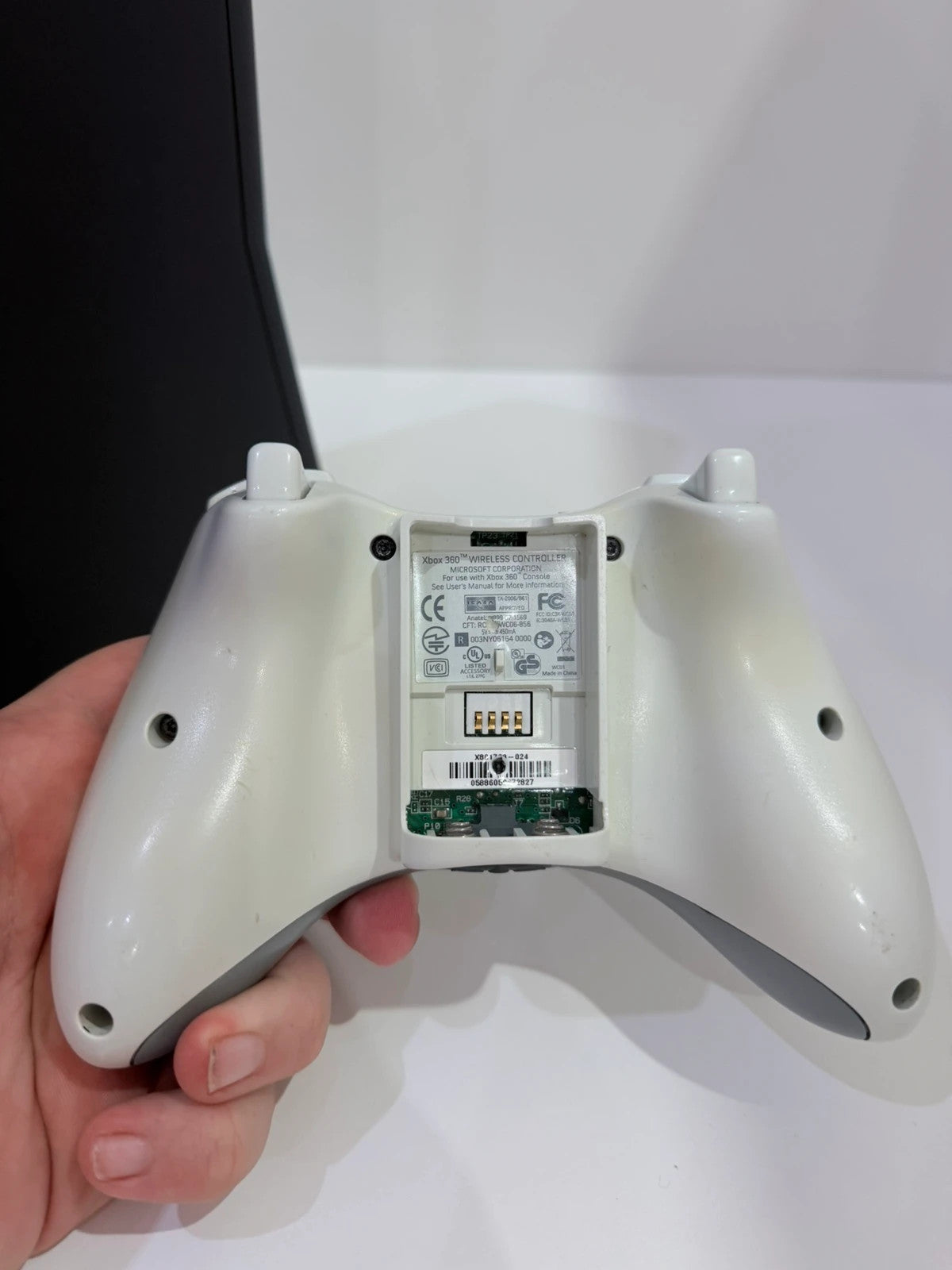Xbox black video game console with white official controller and power supply cables.