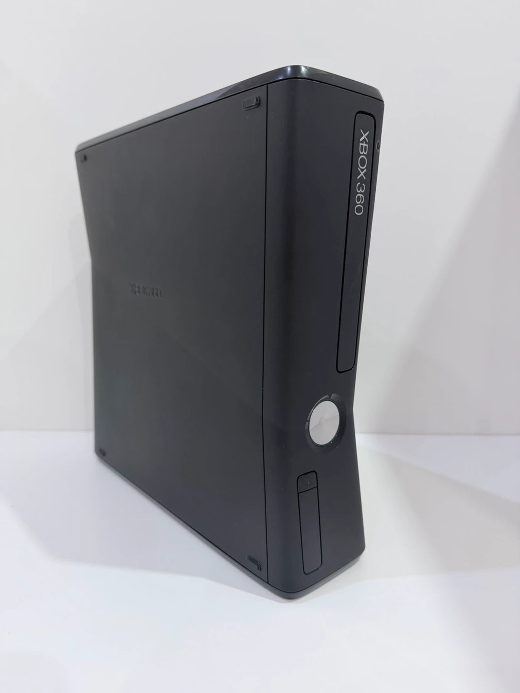 Xbox black video game console with white official controller and power supply cables.