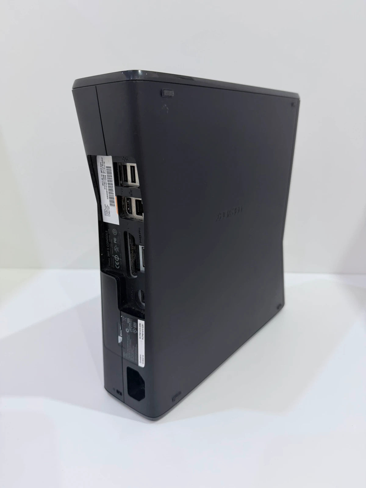 Xbox black video game console with white official controller and power supply cables.