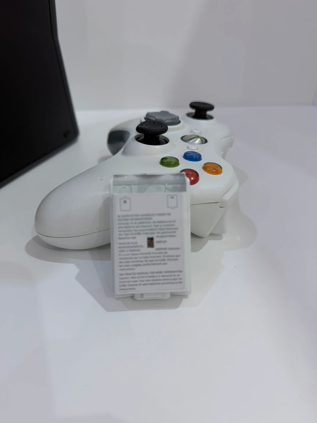 Xbox black video game console with white official controller and power supply cables.