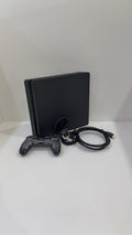 Sony PlayStation 4 Slim 500GB black console with one controller, power and HDMI cables.