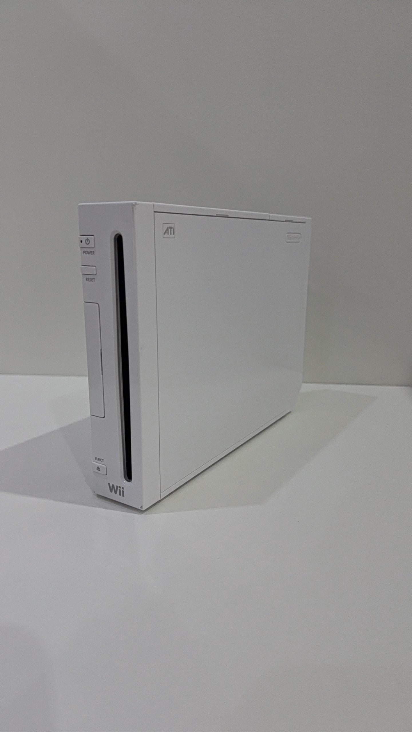 White Nintendo Wii console bundle with official Wii Remote, Nunchuk, cables, and Wii Play game.