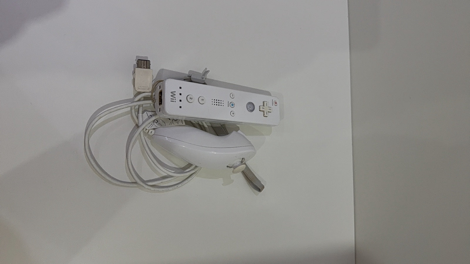 White Nintendo Wii console bundle with official Wii Remote, Nunchuk, cables, and Wii Play game.