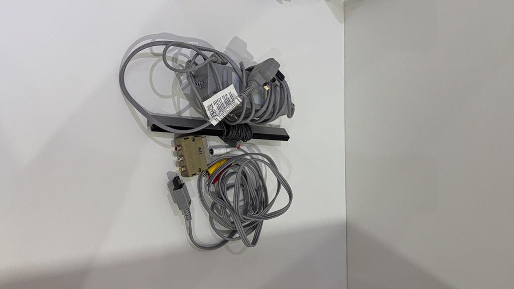 White Nintendo Wii console bundle with official Wii Remote, Nunchuk, cables, and Wii Play game.