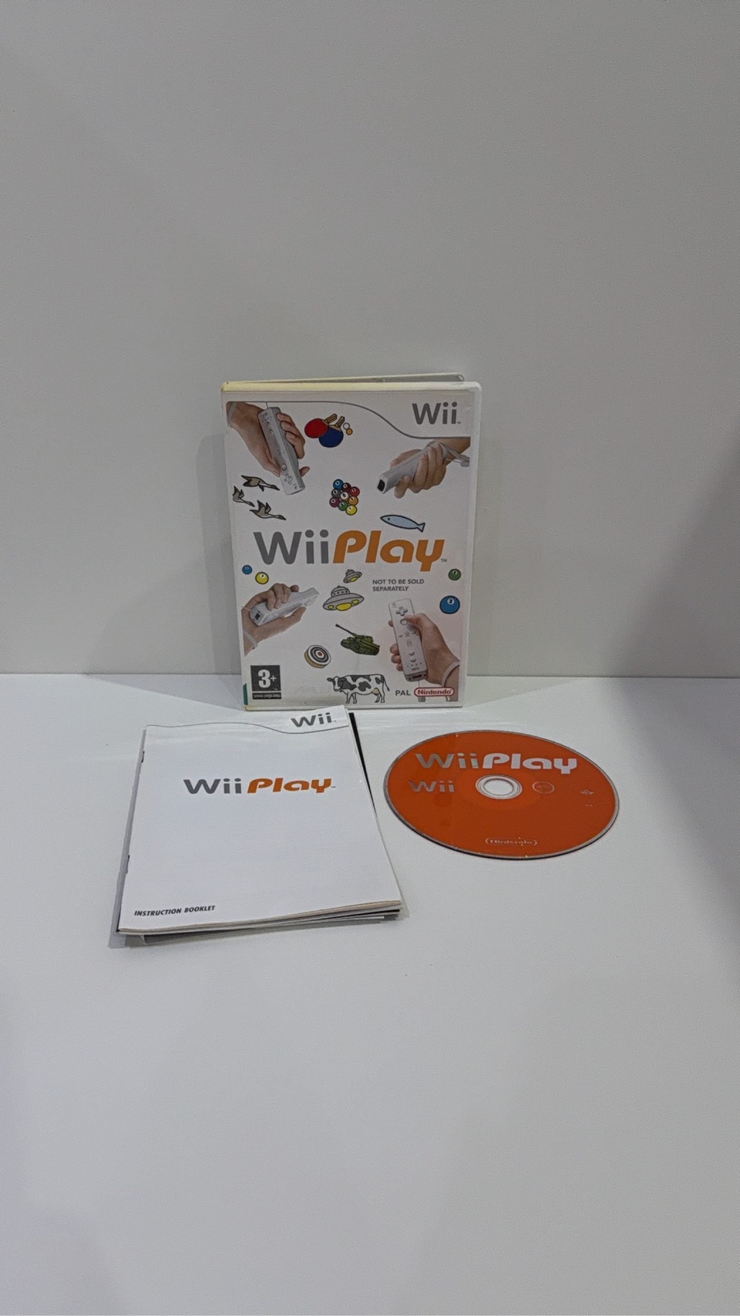 White Nintendo Wii console bundle with official Wii Remote, Nunchuk, cables, and Wii Play game.