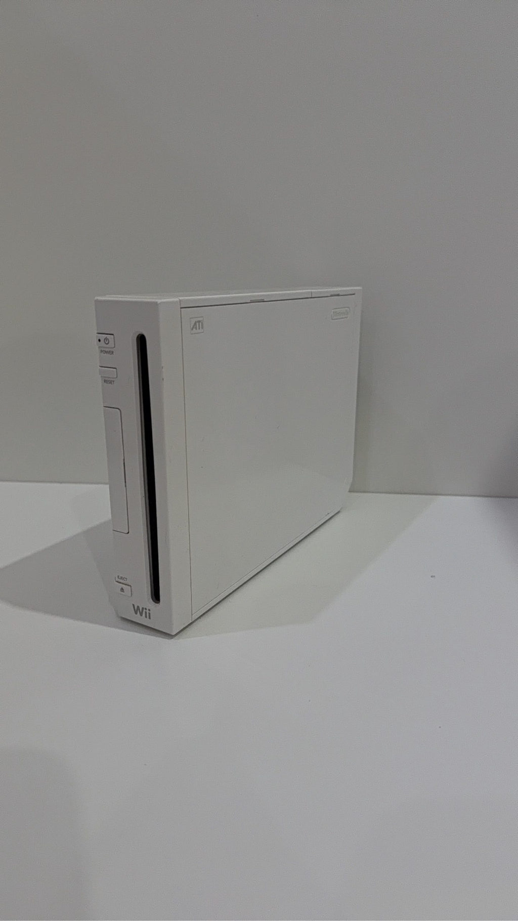 White Nintendo Wii console bundle with official Wii Remote, Nunchuk, and two boxed games.