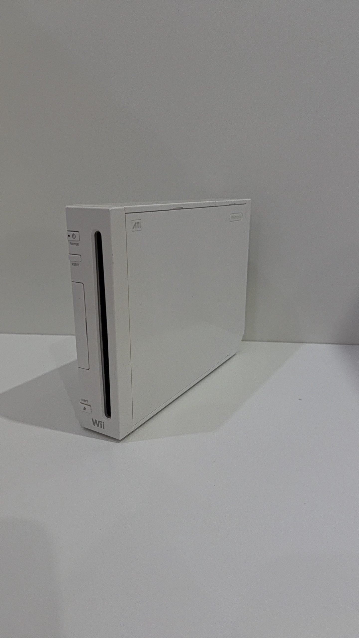 White Nintendo Wii console bundle with official Wii Remote, Nunchuk, and two boxed games.