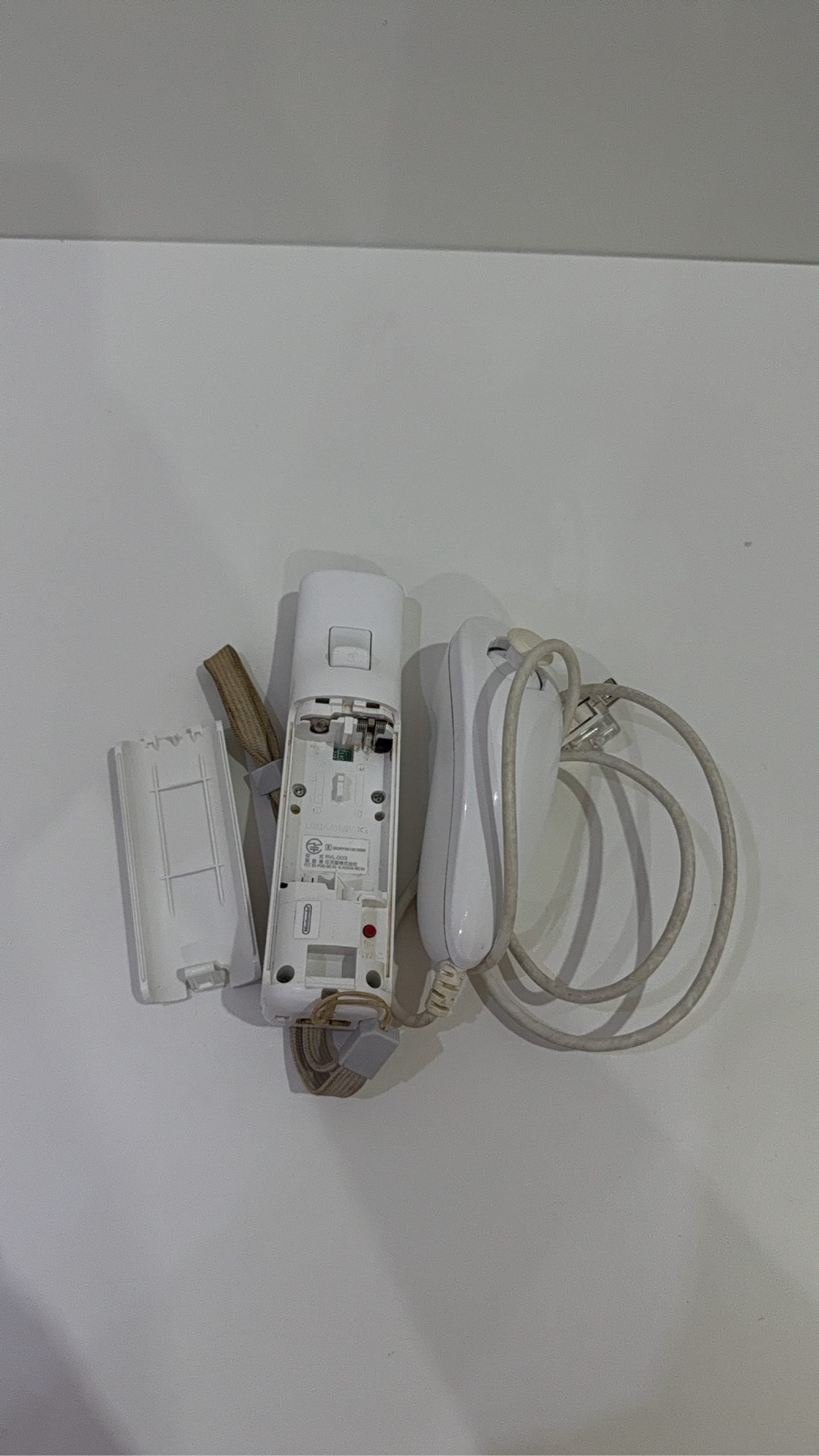 White Nintendo Wii console bundle with official Wii Remote, Nunchuk, and two boxed games.