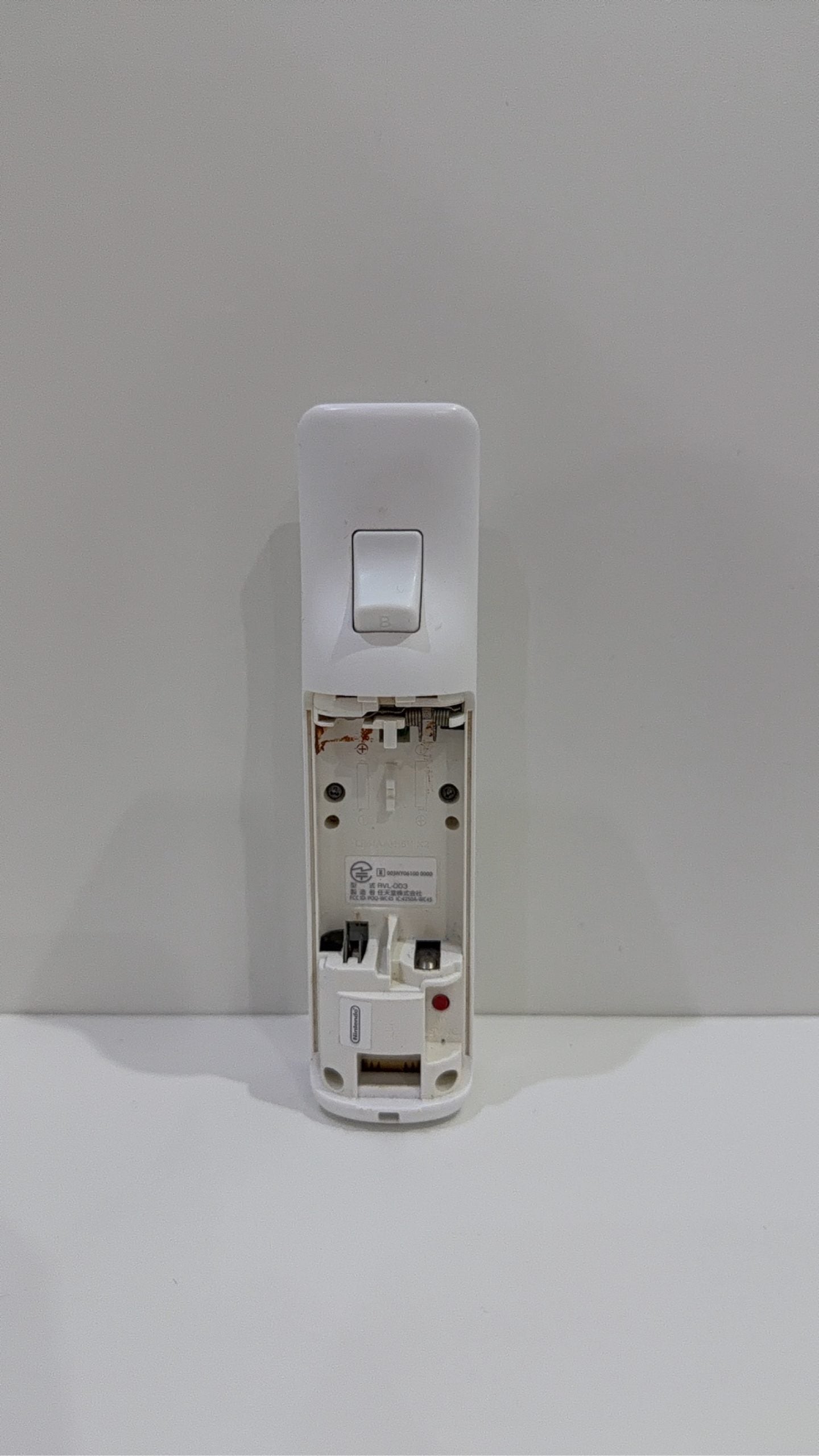 Official Nintendo Wii Remote Controller in white with signs of battery corrosion.