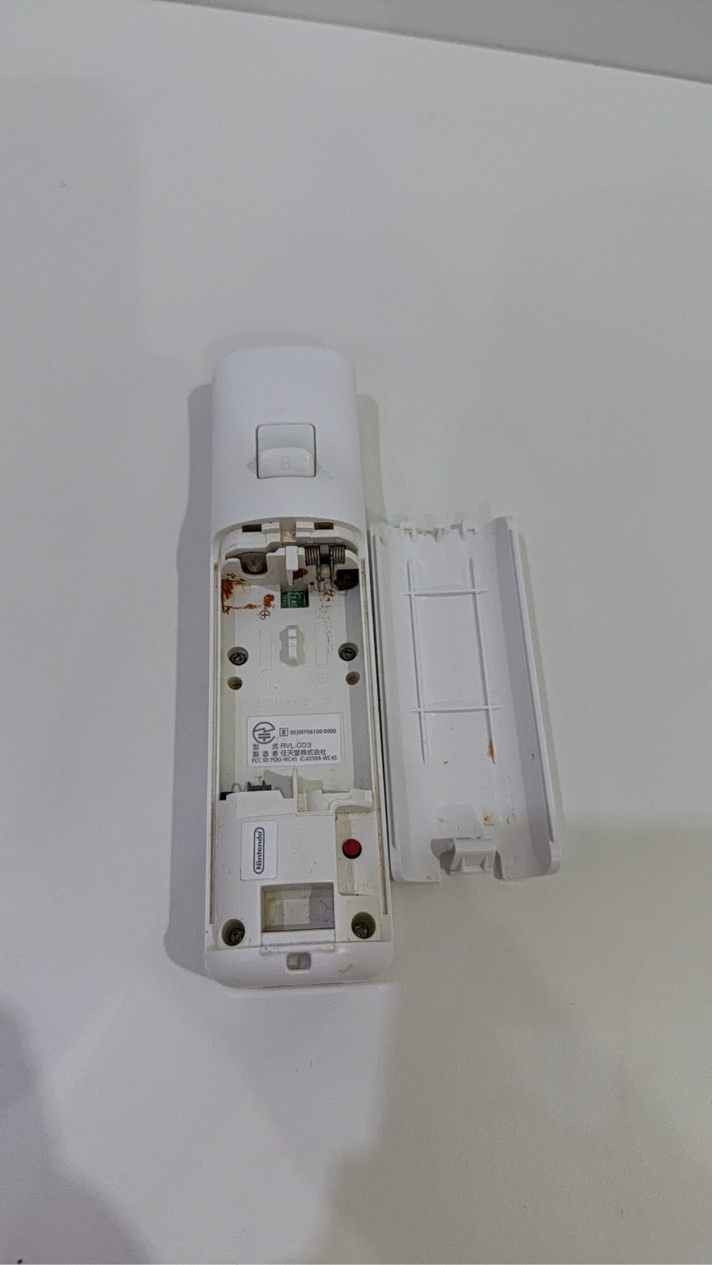 Official Nintendo Wii Remote Controller in white with signs of battery corrosion.