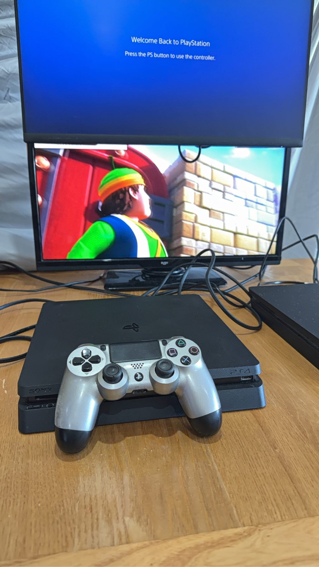 PlayStation 4 Slim PS4 Black 500GB console with official silver Dualshock 4 controller.