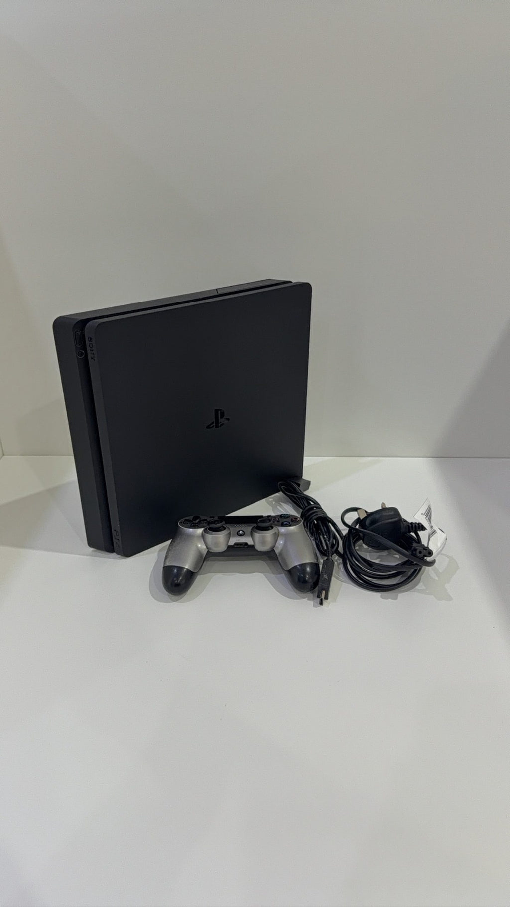 PlayStation 4 Slim PS4 Black 500GB console with official silver Dualshock 4 controller.