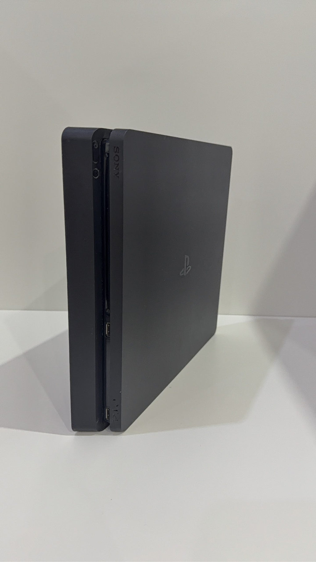 PlayStation 4 Slim PS4 Black 500GB console with official silver Dualshock 4 controller.