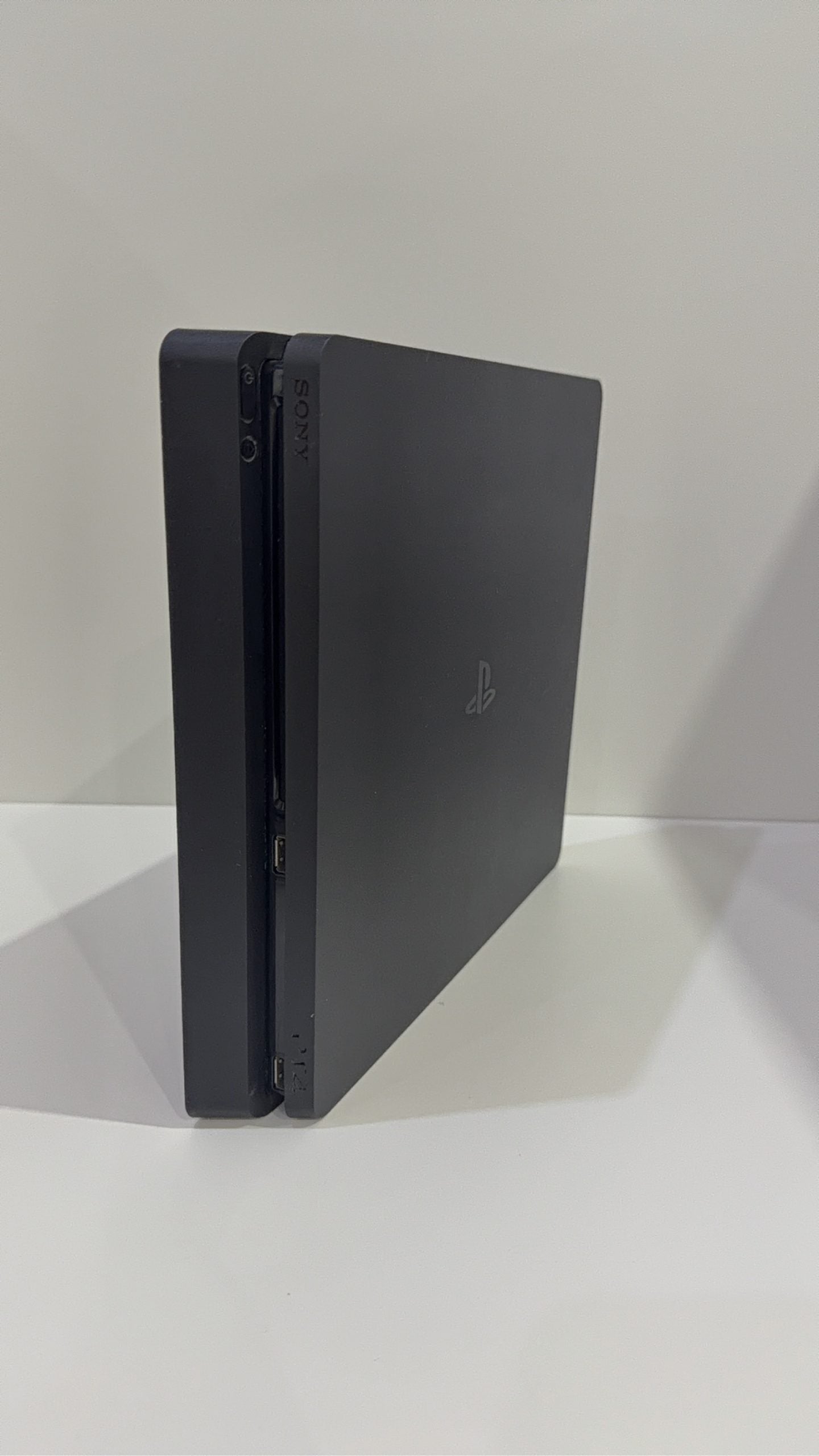 PlayStation 4 Slim PS4 Black 500GB console with official silver Dualshock 4 controller.
