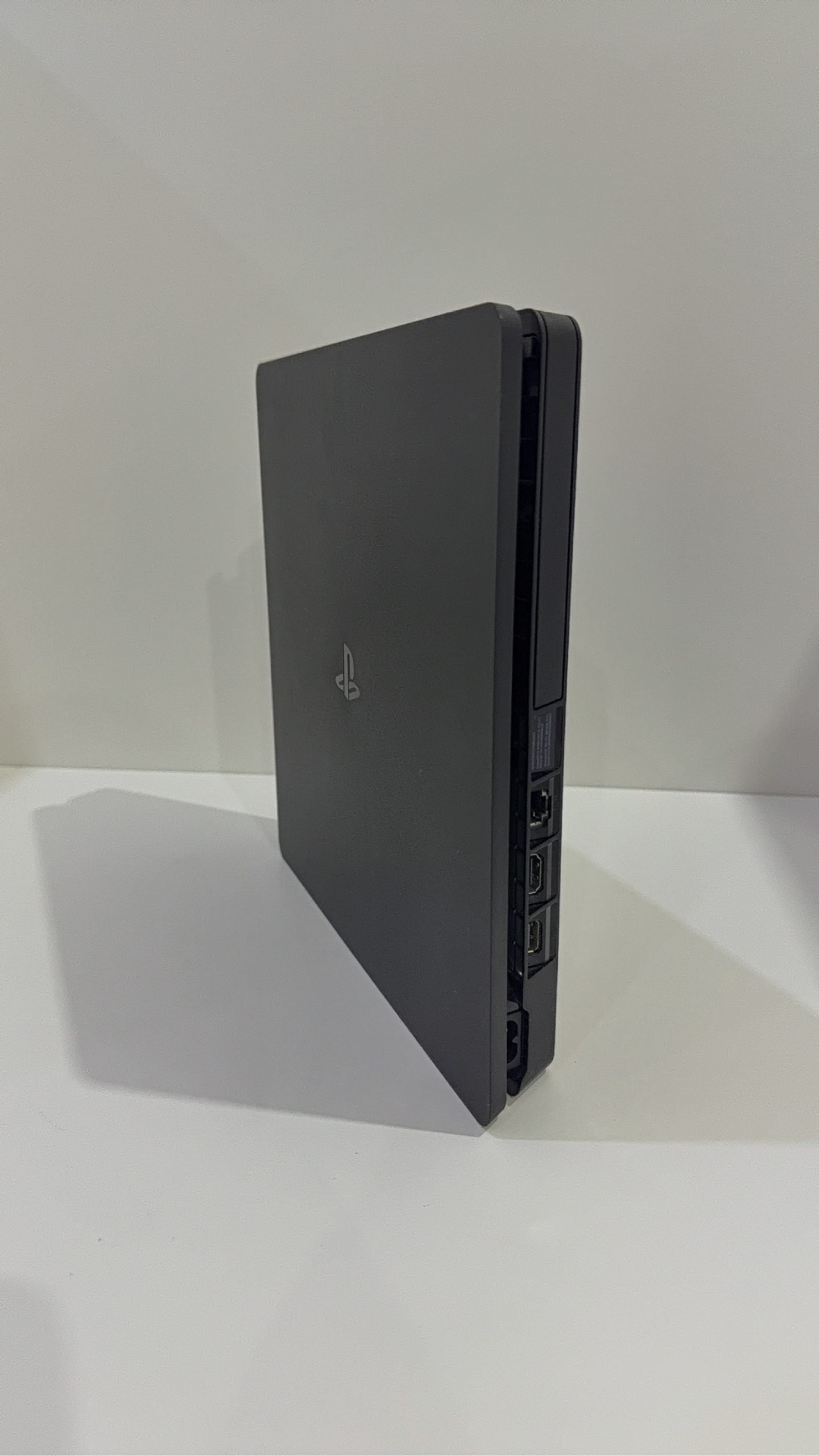 PlayStation 4 Slim PS4 Black 500GB console with official silver Dualshock 4 controller.